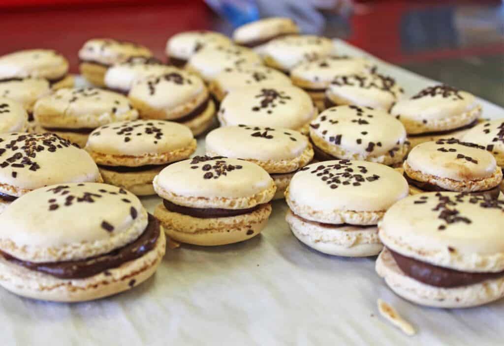 A number of finished chocolate and salted caramel macarons