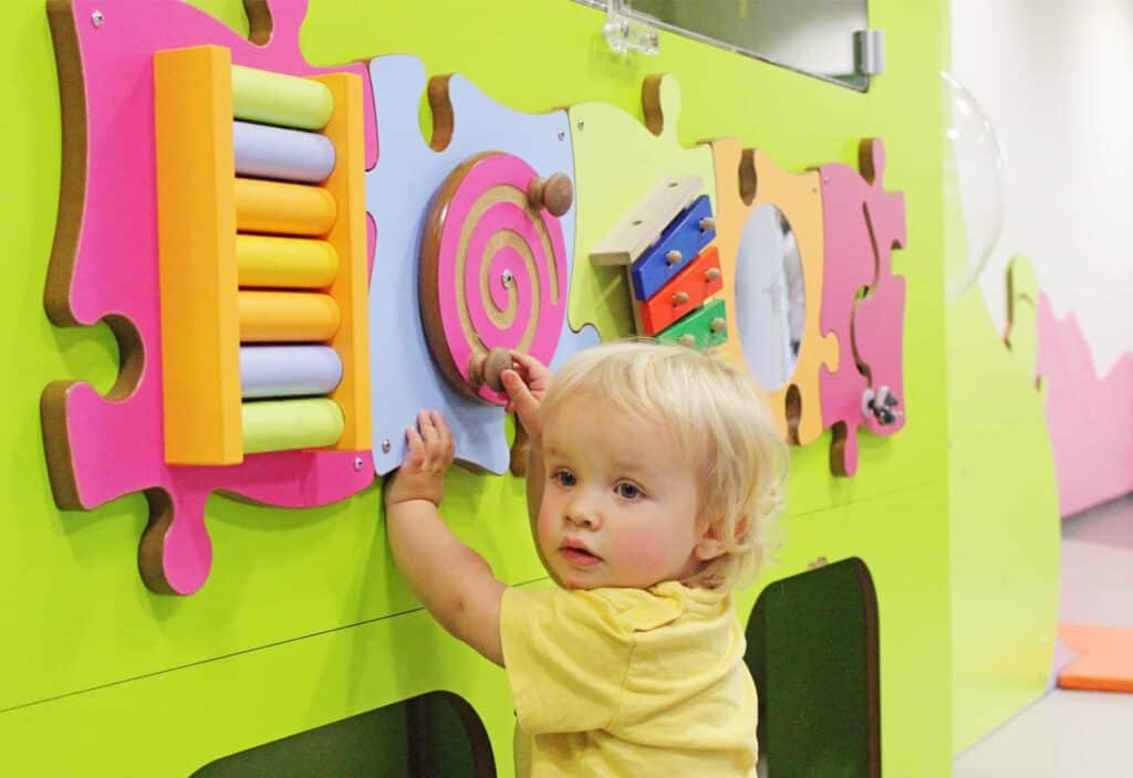 toddler playing with colourful toys at geneva airport kids area