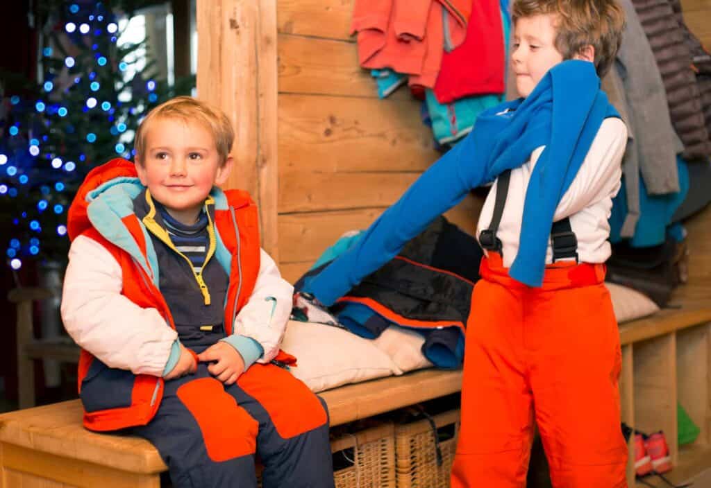 Two young children getting to out in the snow