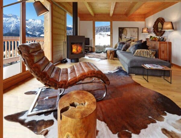 A curved leather chair, a cowhide, slices of tree, a deep fabric sofa, and patterned cushions combine to make a really inviting lounge space at Chalet Chocolat.