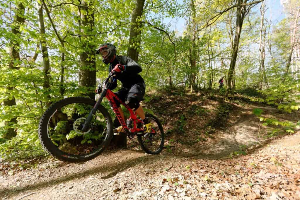 A mountain biker riding the red Downhill La Ferriaz in La Clusa