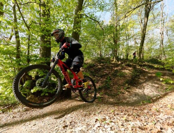A mountain biker riding the red Downhill La Ferriaz in La Clusa