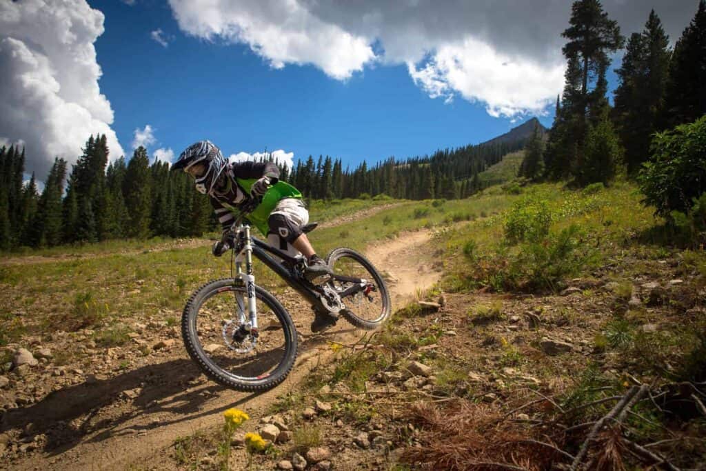 A mountain biker riding the blue downhill trail in La Clusaz