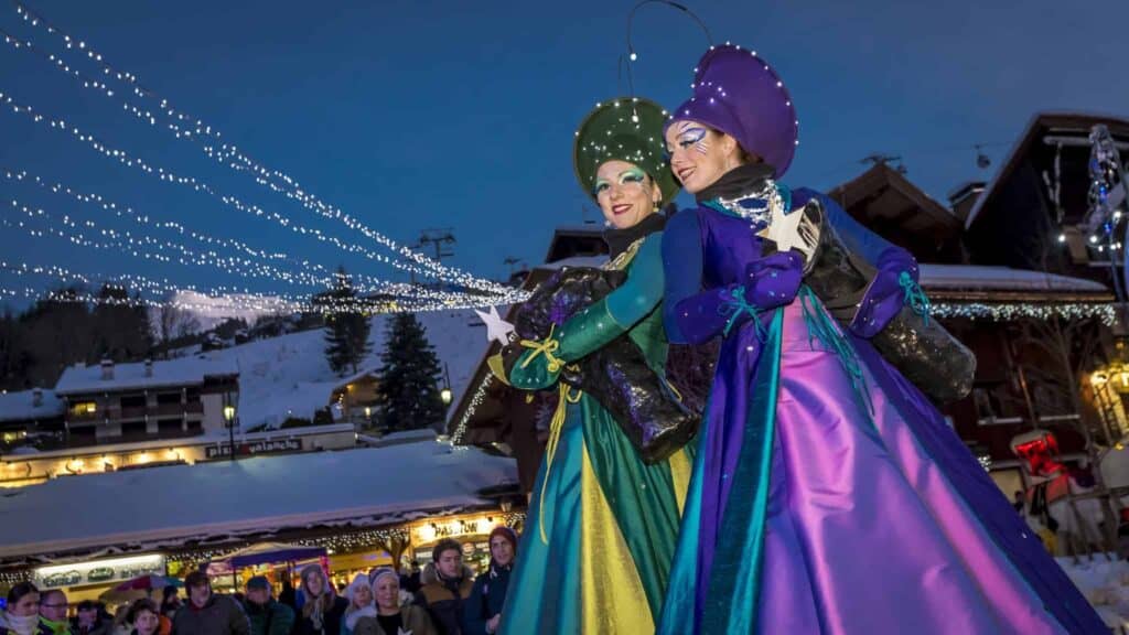 Two women in costumes surrounded by lights for a show.