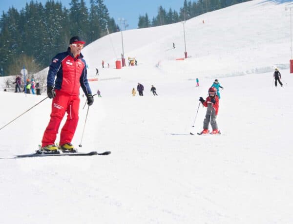 An ESF instructor with a young pupil skiing on a beginner slope in Manigod