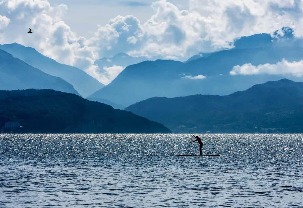 Stand-up paddle sur le lac d’Annecy et les montagnes en toile de fond.