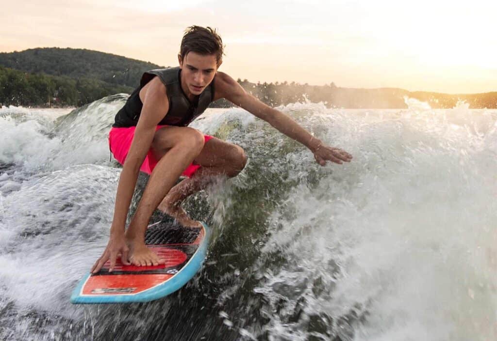 Jeune homme faisant du wake surfing sur le lac d'Annecy.