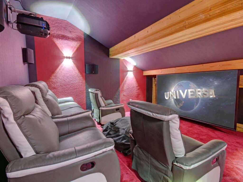 A home cinema with large armchairs and screen.