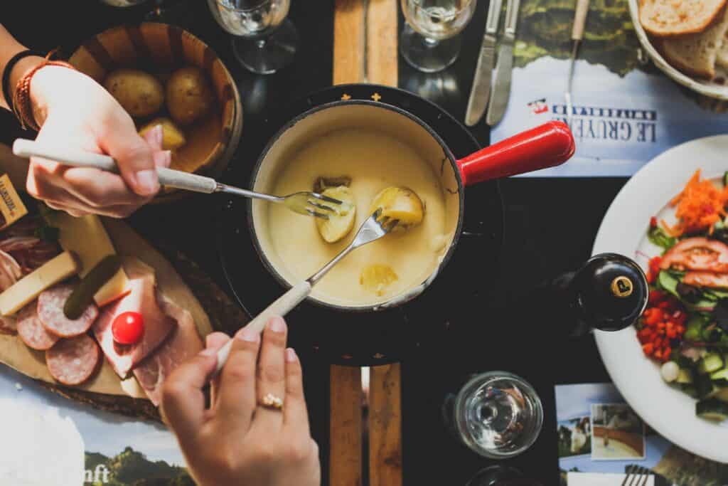 A fondue dish from above, with ingredients all around on the table.