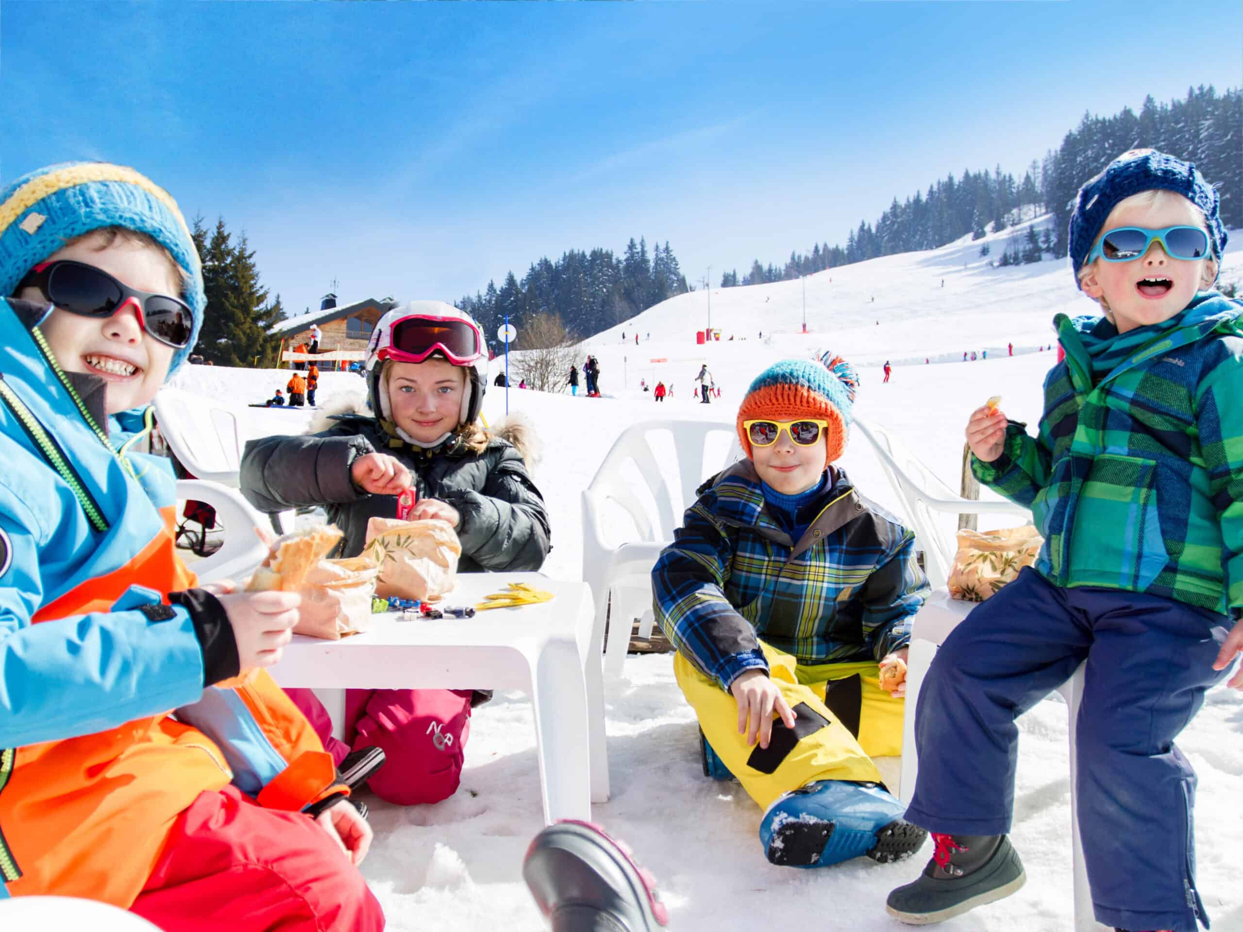 Des enfants en train de goûter dans une garderie au ski.