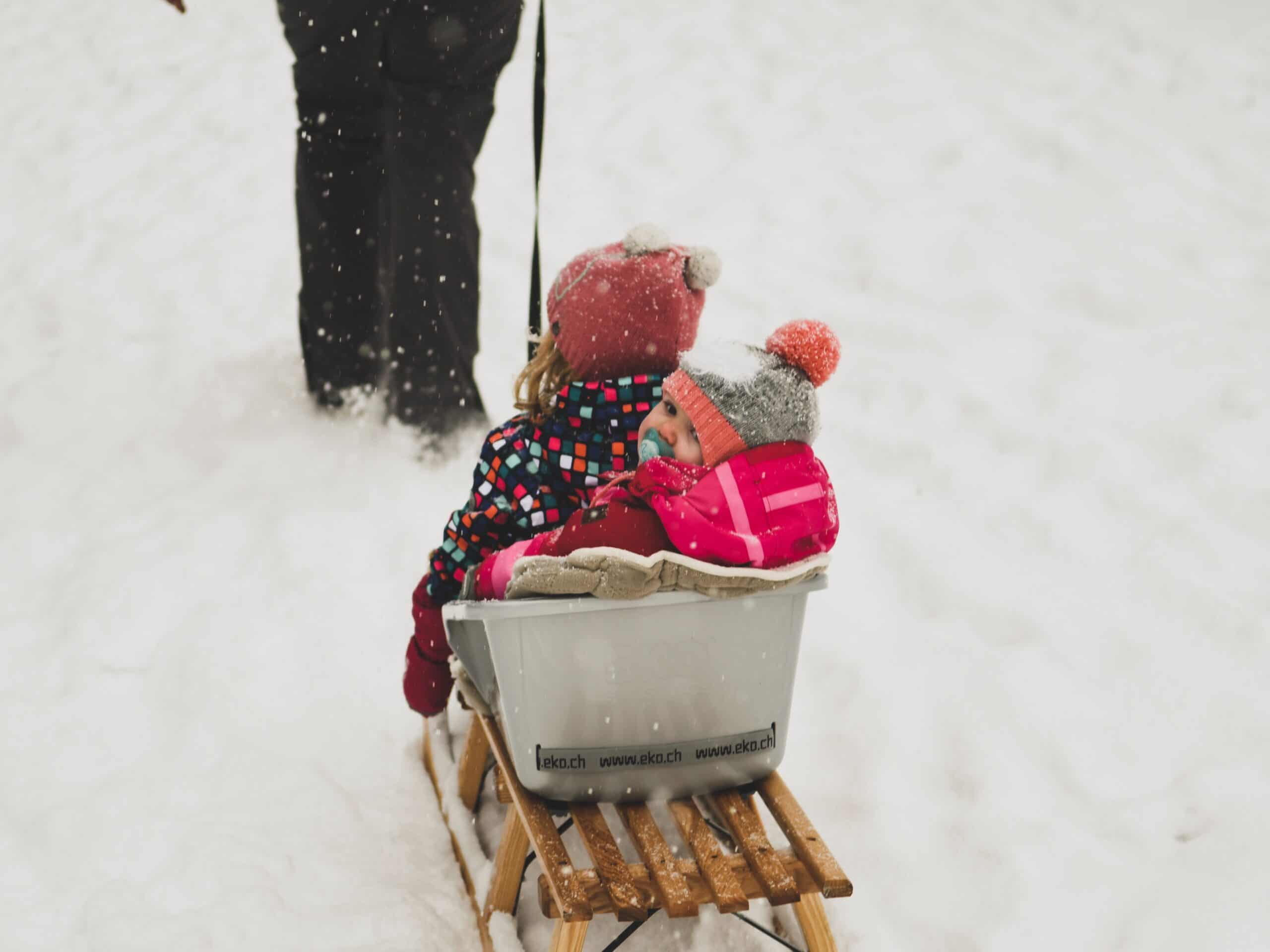 Des enfants qui se font tirer dans une luge au sein d'une garderie au ski.
