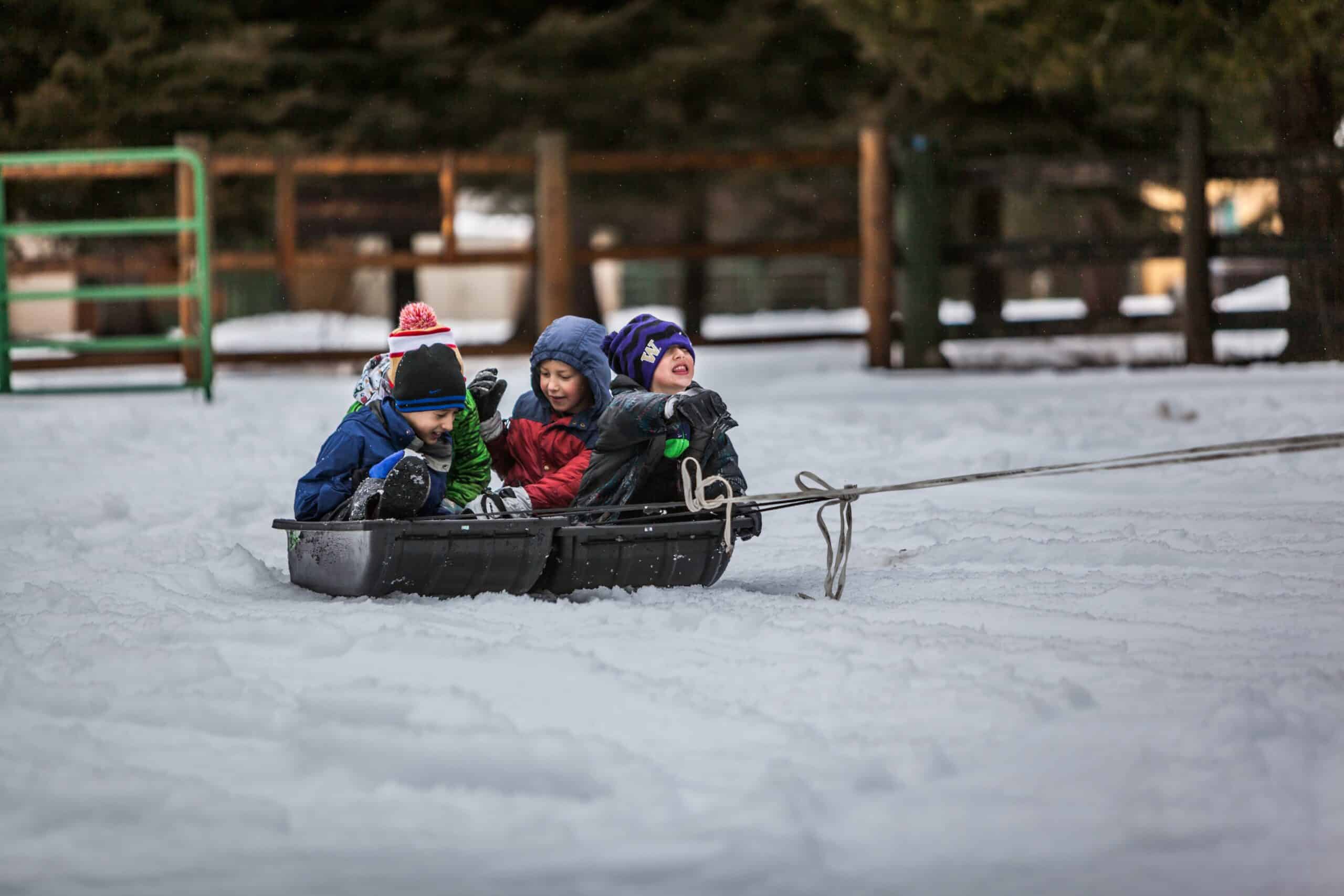 Des enfants qui se font tirer dans une luge au sein d'une garderie au ski.