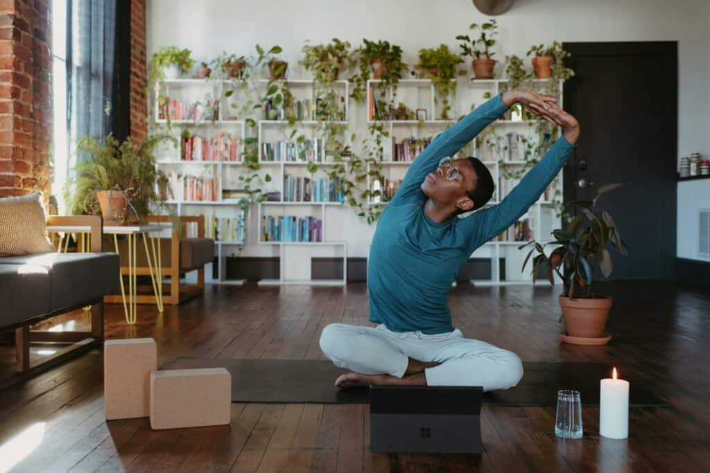 A person doing yoga with lots of plants in the background
