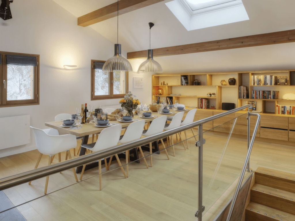 A neutral coloured dining space at Chalet Riparian with feature shelving storing books and accessories.