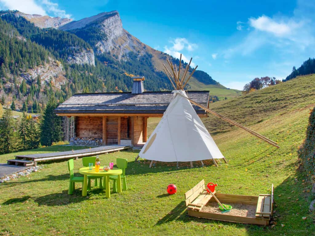 A wigwam, sandpit and other toys outside Authentic Lodge Spa in La Clusaz