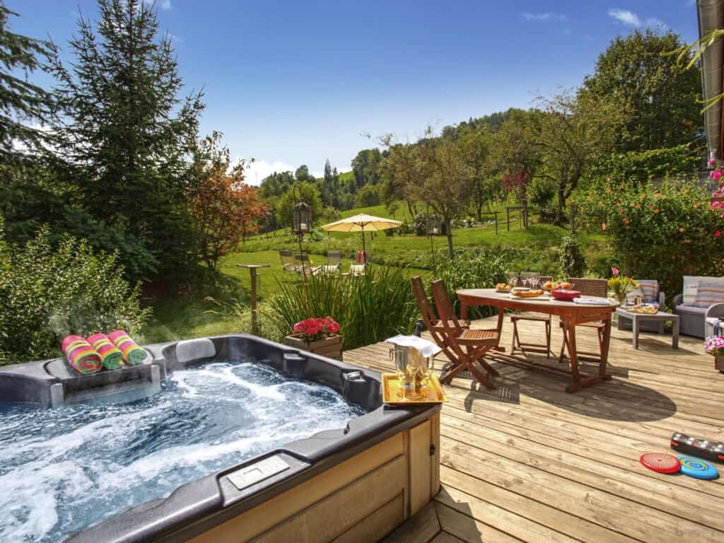 A bubbling hot tub on the furnished terrace at Chalet Les Roses Des Alpes