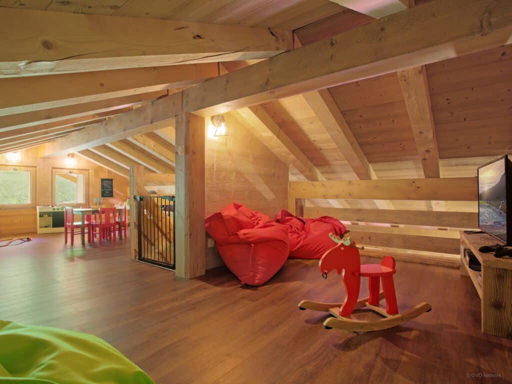 Playroom with rocking horse and red poufs.