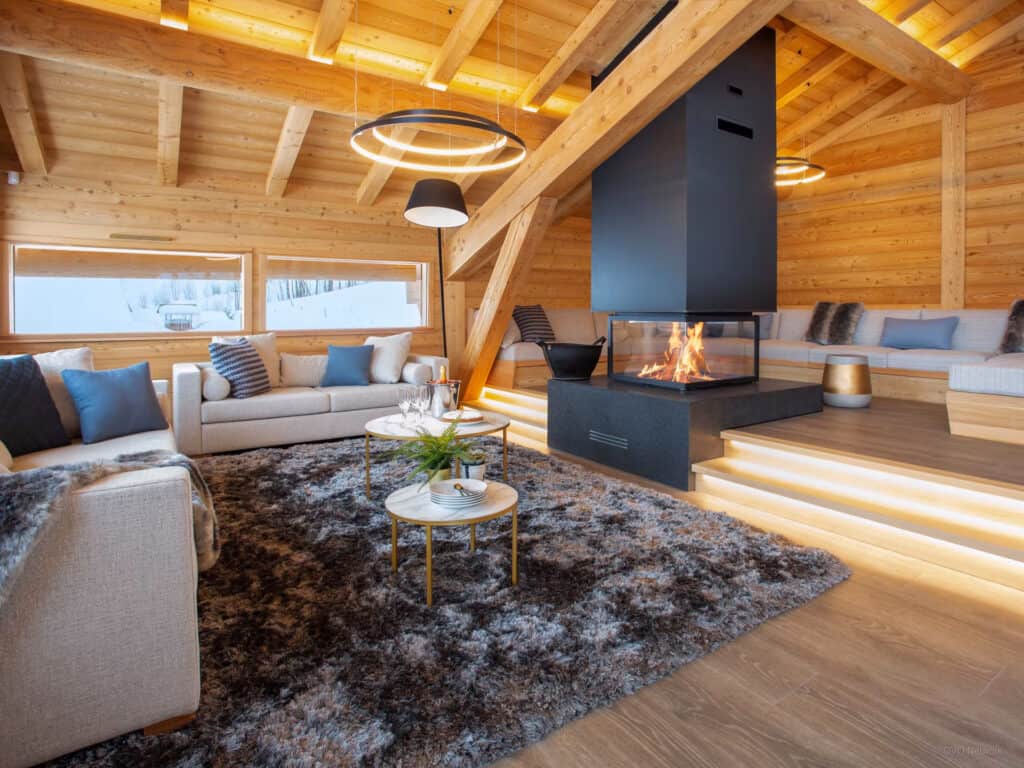 Salon moderne en bois avec cheminée et grand tapis douillet.