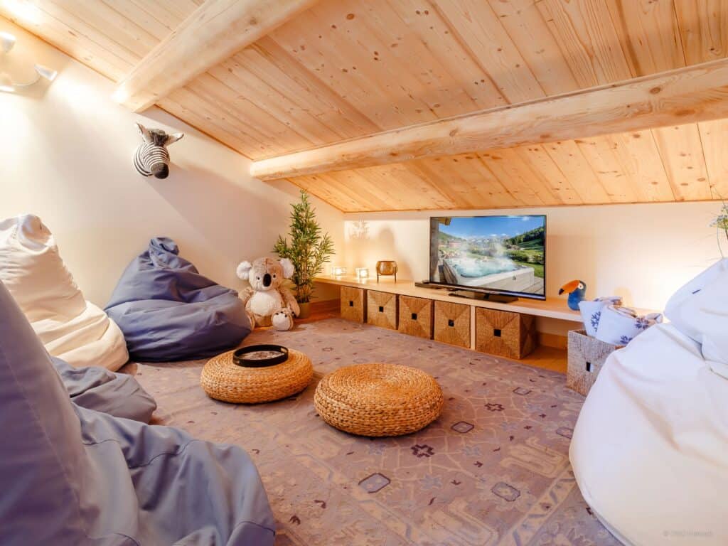 TV room with pouf and a teddy bear at Chalet Joux Verte