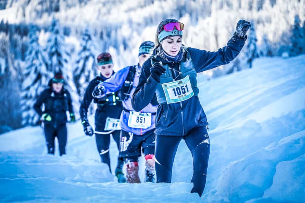 Racers running through the snow at the Morzine Spartan Race