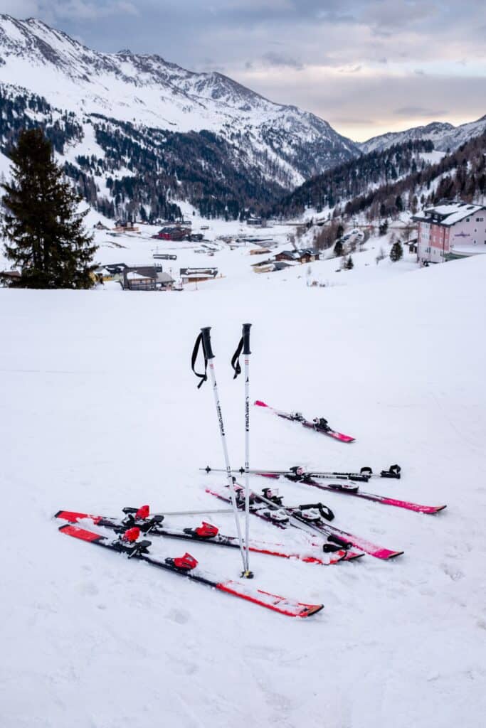 Skis et bâtons dans la neige au soleil couchant.