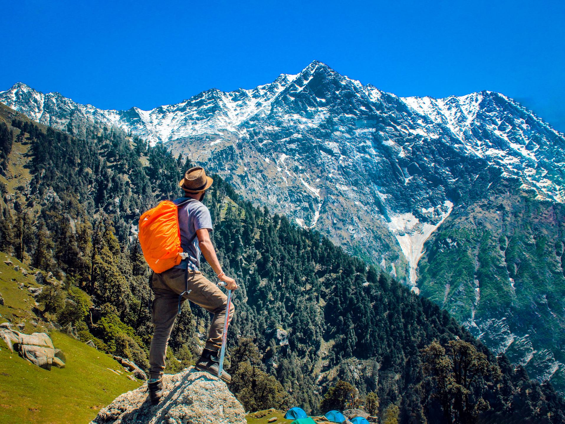 A hiker stands on a rock enjoying the wonderful mountain view