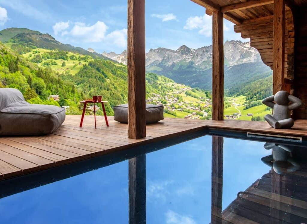 The outdoor swimming pool at Chalet Happyview with its magnificent view over the valley and mountains