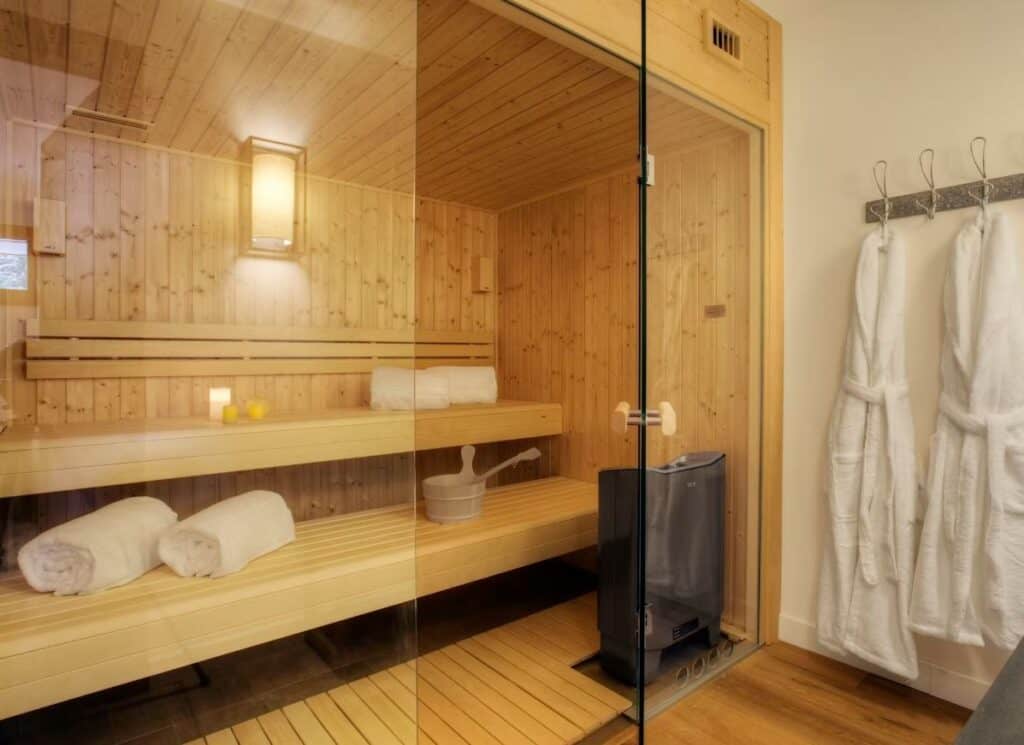 L'intérieur d'un sauna privé en bois, avec sorties de bain pendues à l'entrée.