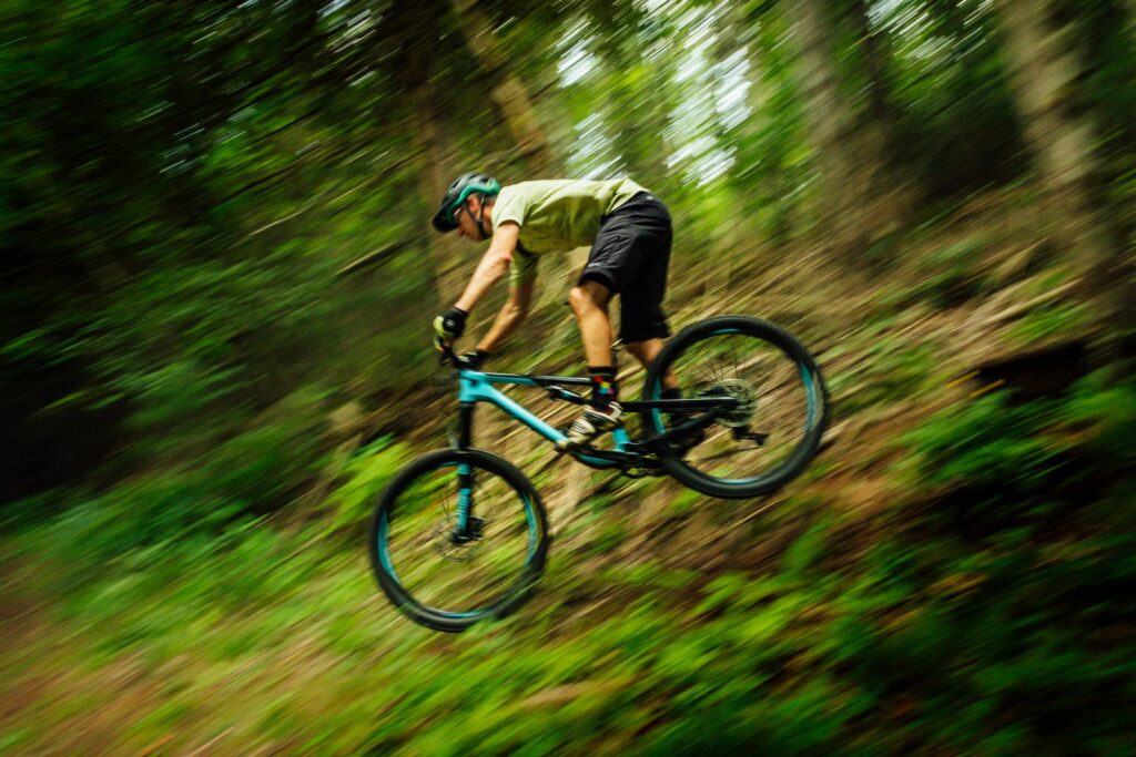 A cyclist hurtles down a steep slope on a mountain bike