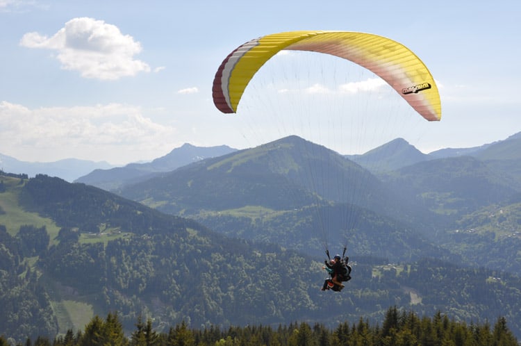 A paraglider soars over the mountains