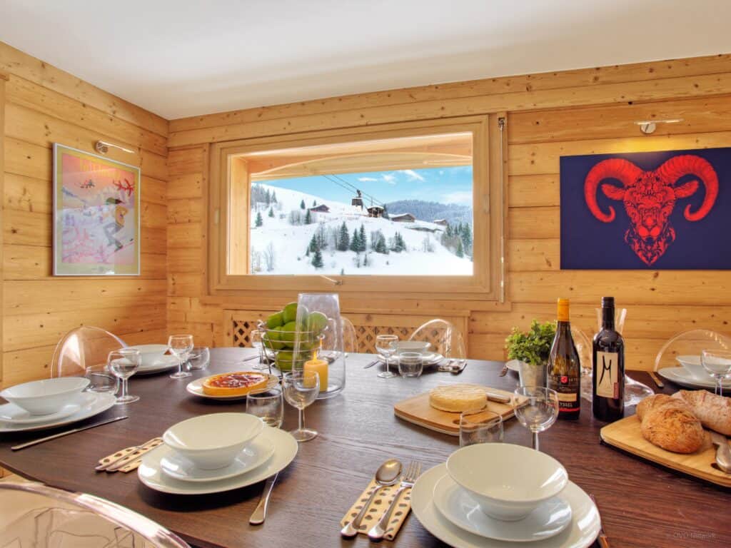 Une grande salle à manger lumineuse avec des imprimés audacieux accrochés aux murs en bois.