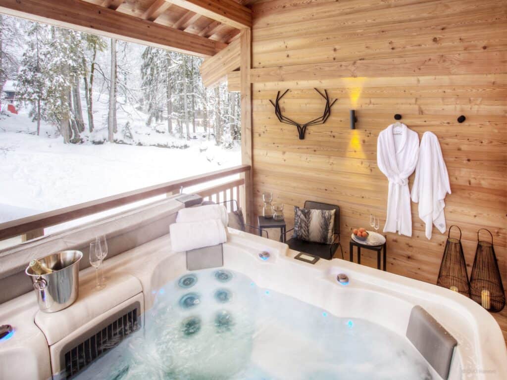 Un spa extérieur de luxe avec un mur orné d'une tête de cerf et des peignoirs de bain.
