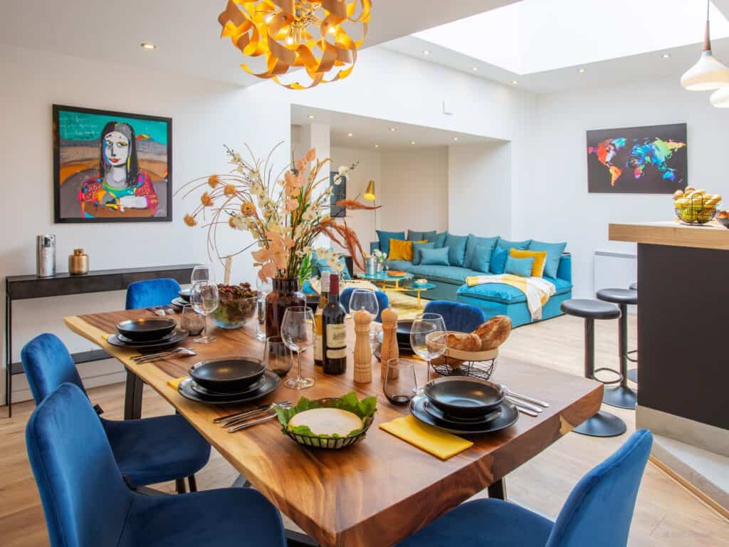 A colourful dining space featuring bold paintings and wall art.