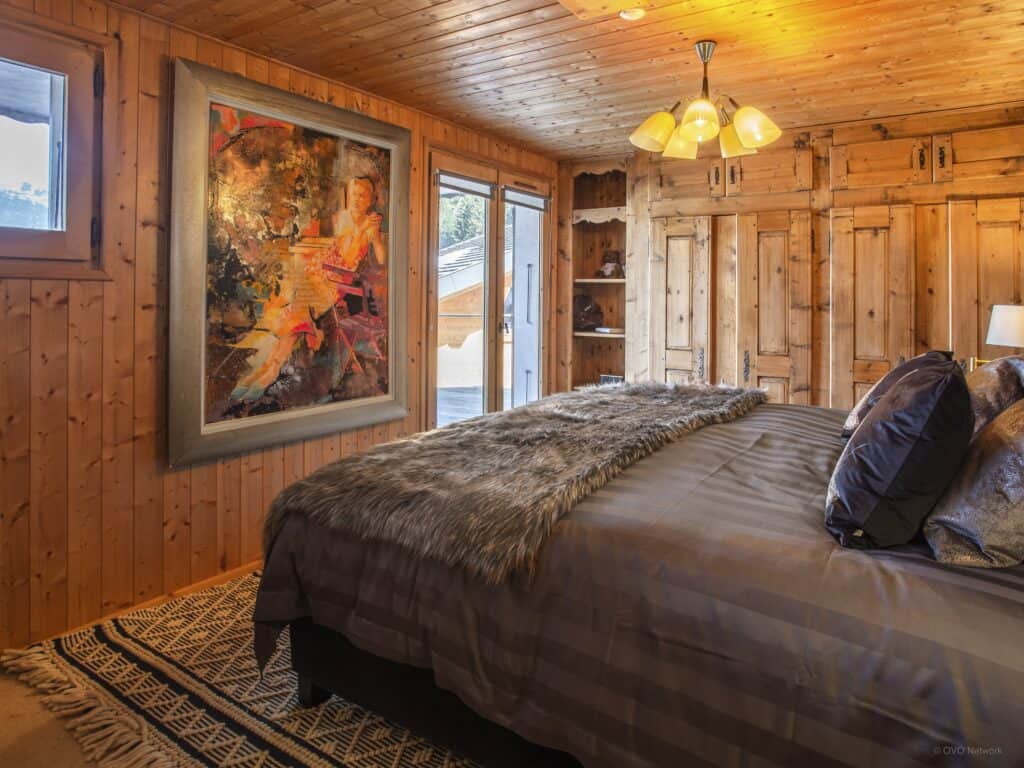 Une chambre à coucher glamour avec un grand tableau représentant une femme assise.