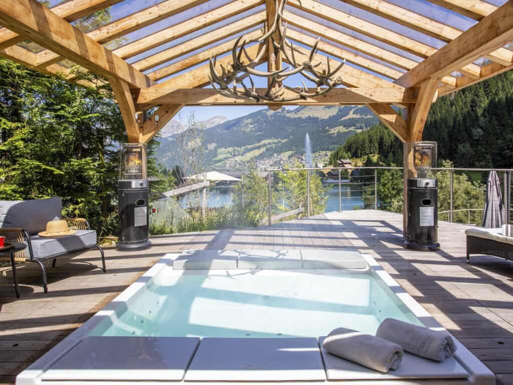 The impressive hot tub at Chalet Ruisselet with outdoor heaters and antler chanedlier.