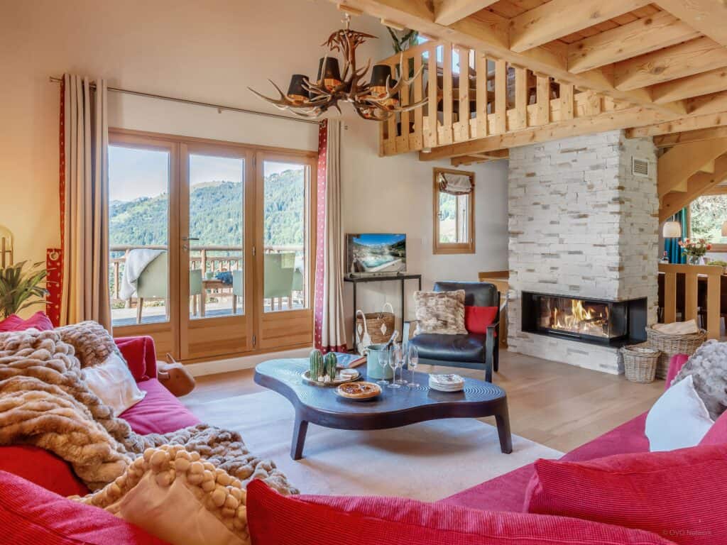 Living room with red sofas and fireplace at Chalet Joux Verte