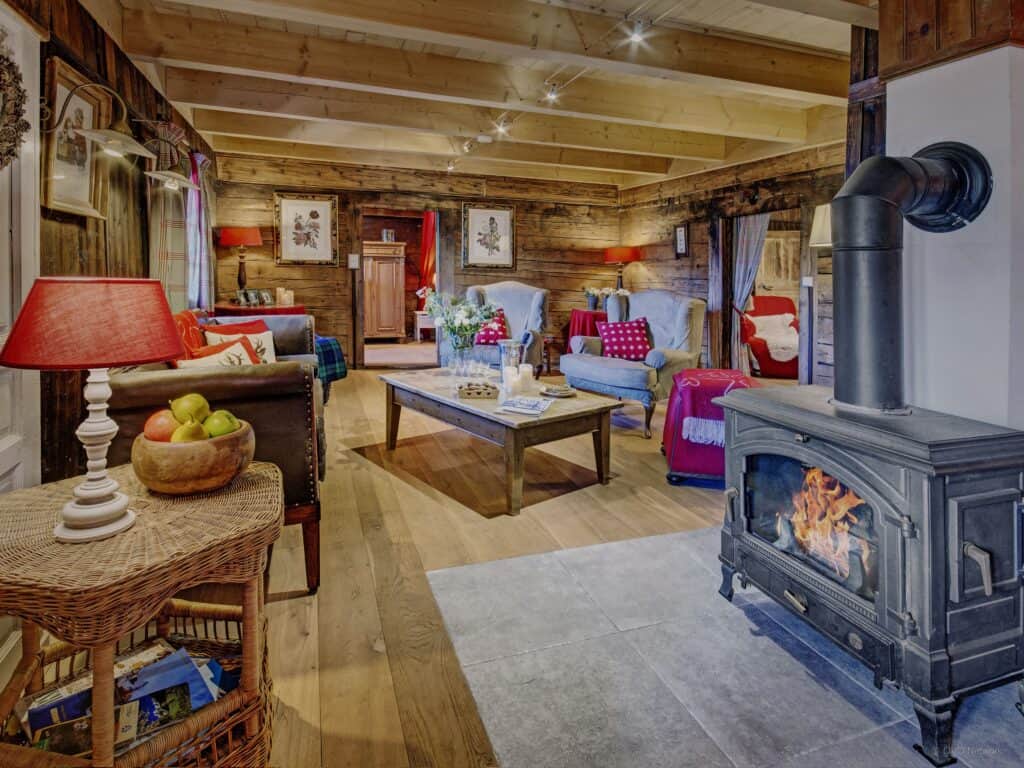 Chalet le Meridien Etale authentic Alpine living space with log burning stove and table lamps