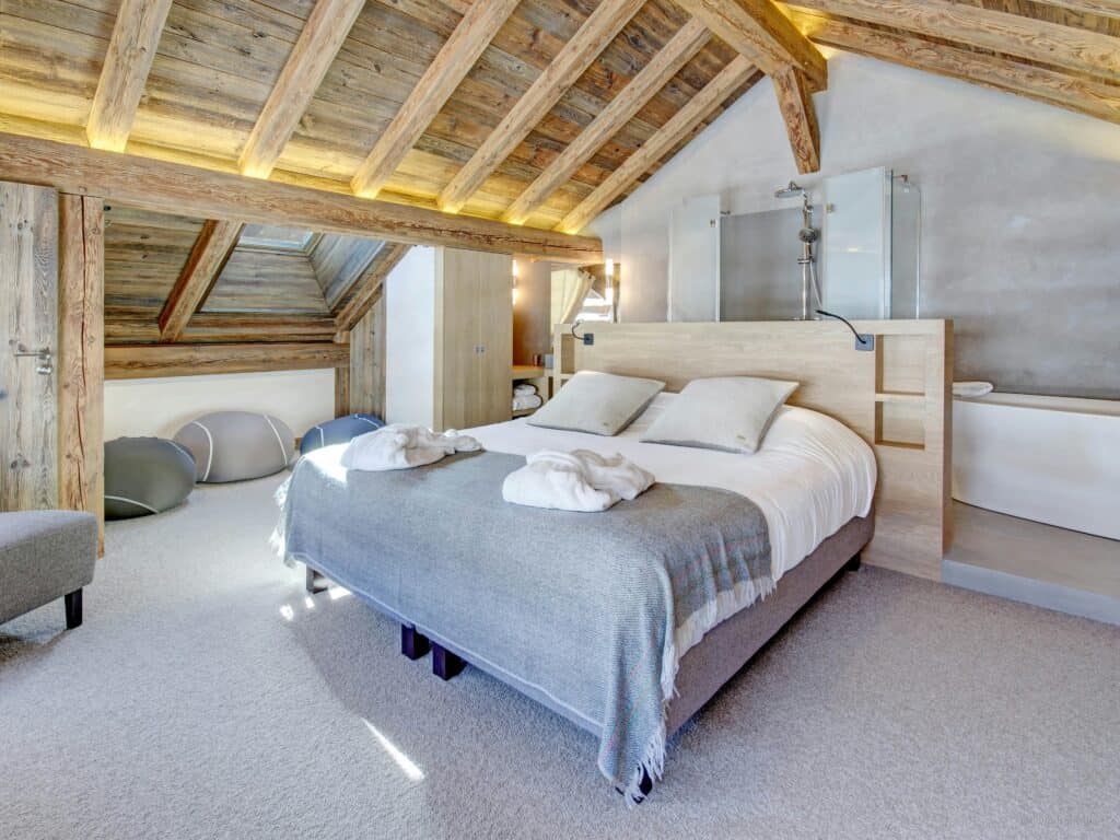 Luxury bedroom with grey bed and en suite bathroom