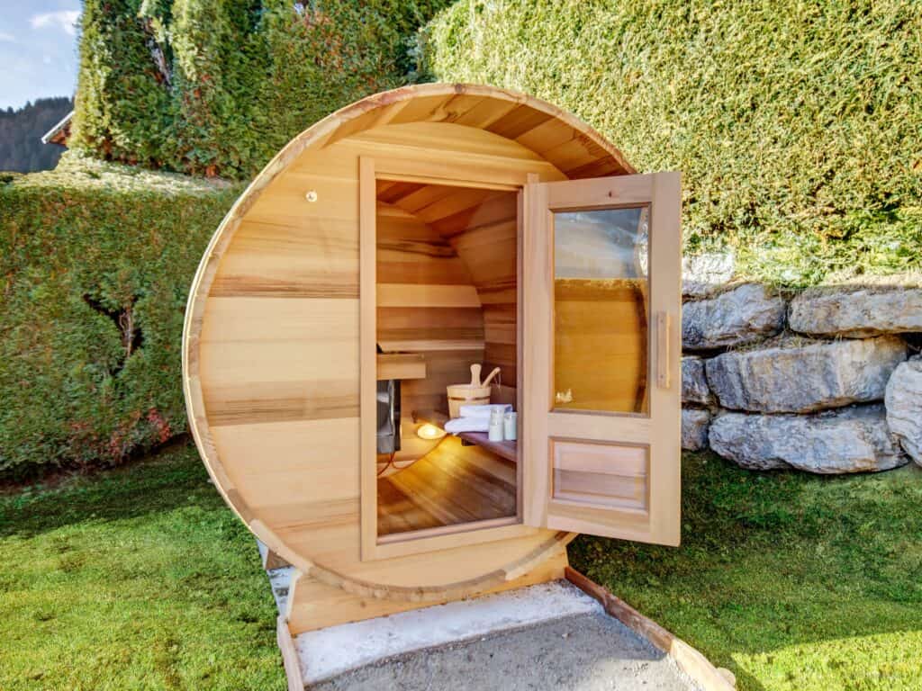 Le sauna tonneau du chalet Alyssum sur une pelouse.