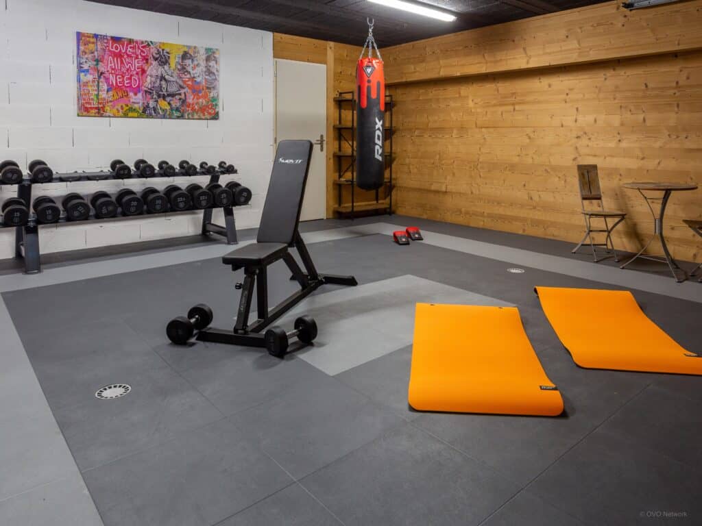 Salle de sport avec tapis de yoga, miroir et banc de musculation