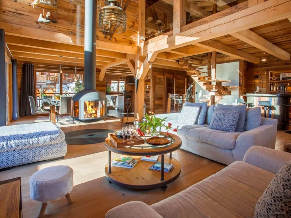 A cosy central fireplace at Chalet Saboroc, surrounded by sofas