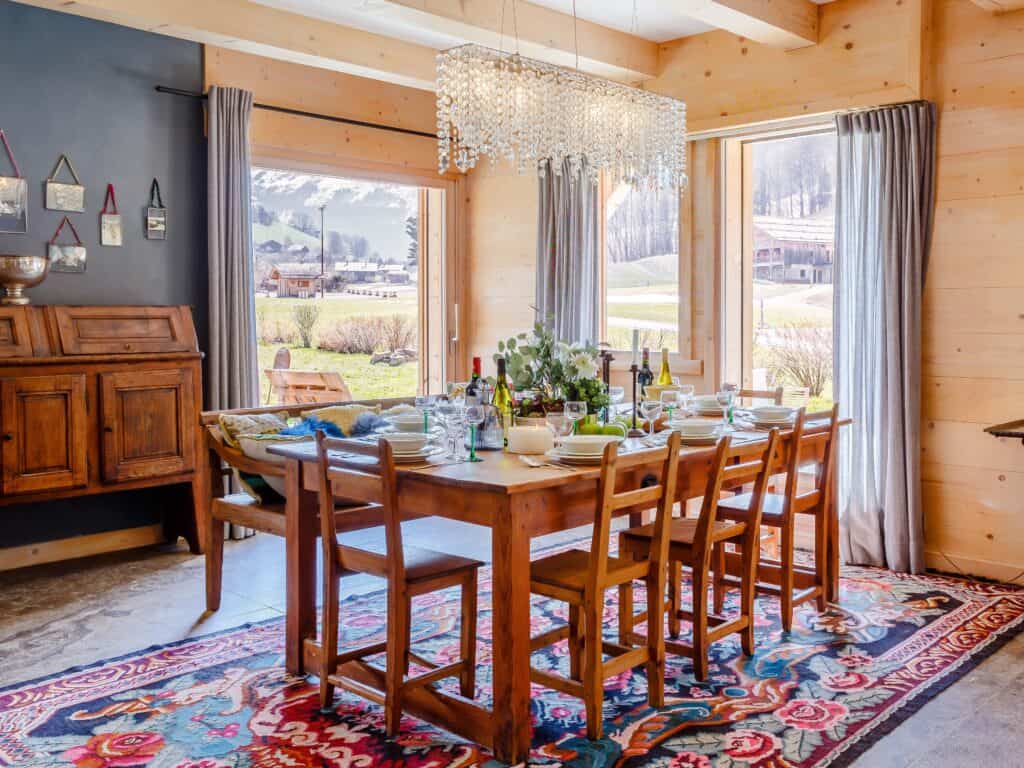 Chalet Ibusta's dining room with traditional chalet decoration including a colourful rug beneath the dining table