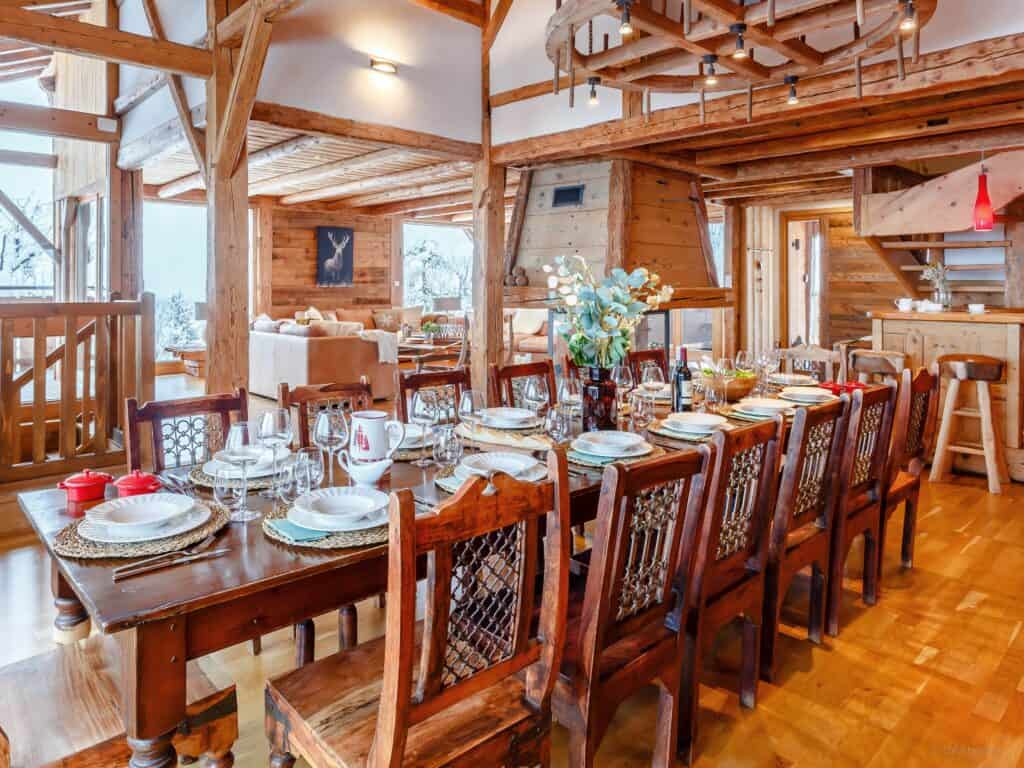 Chalet Keramis' dining room with large wood table, chandelier and chairs