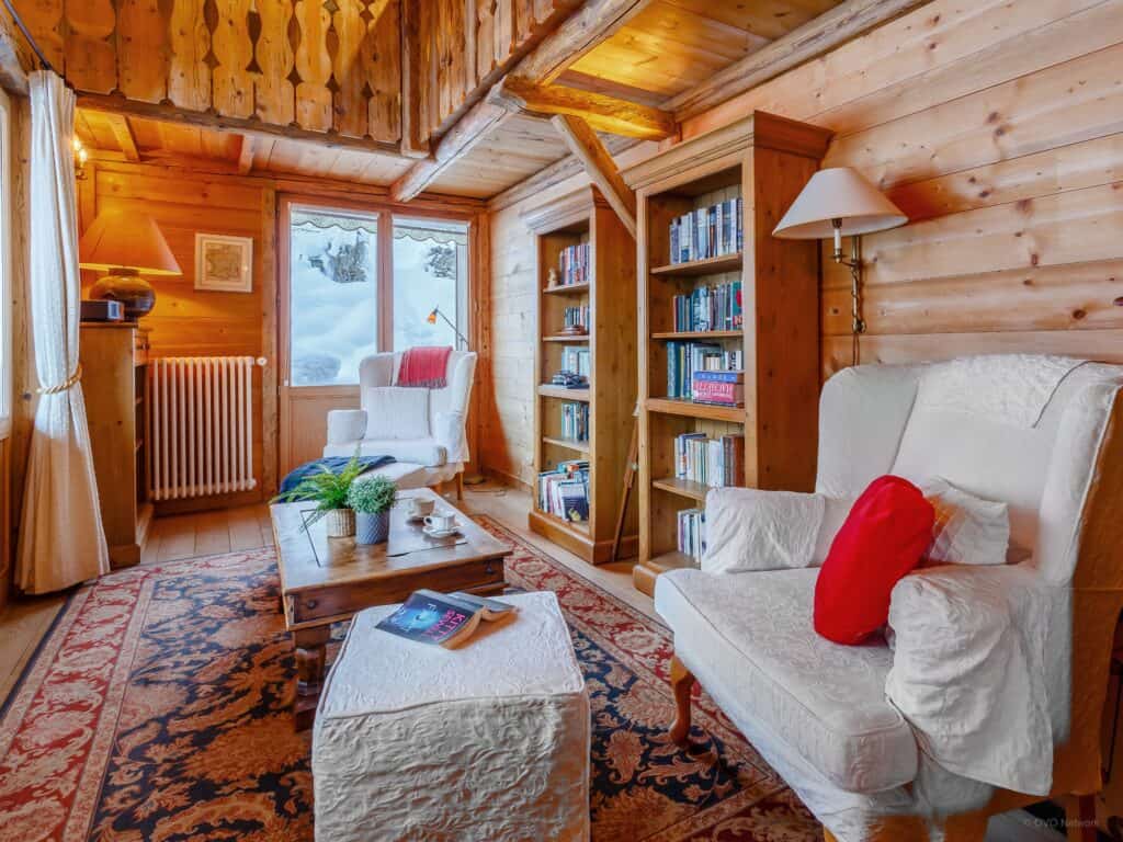 Traditional chalet decoration in Chalet Gueret's living space with bookshelves and a pair of chairs