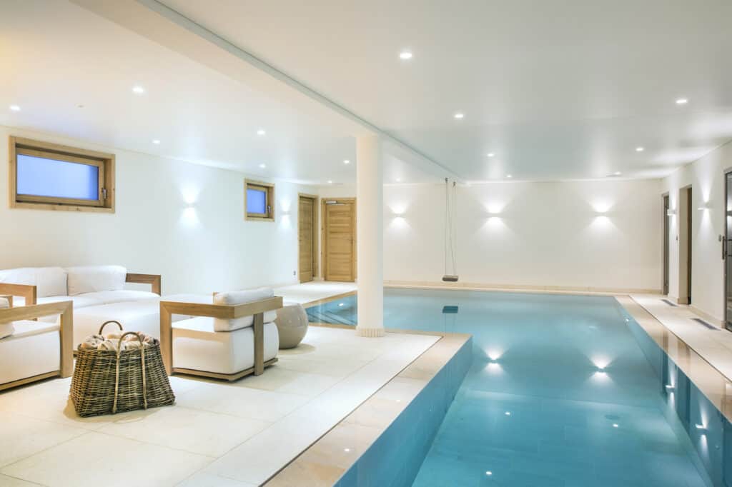 Une piscine couverte moderne et luxueuse avec une balançoire.