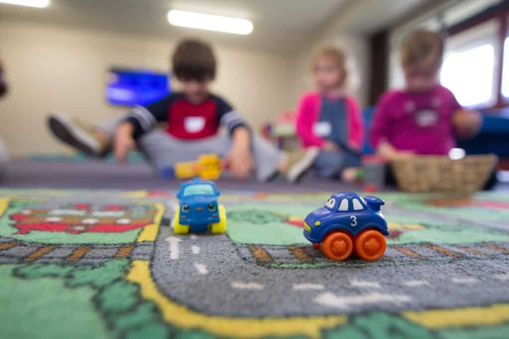 Jeunes enfants jouant à un petit circuit à la garderie dans les Alpes. 