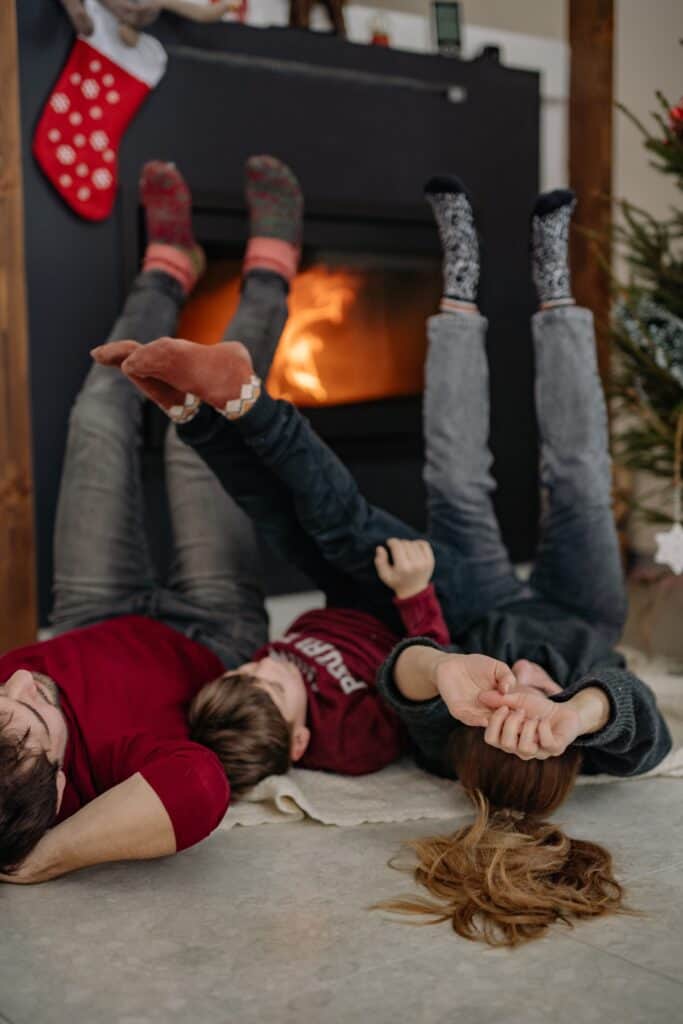 A family warm their feet in front of a wood-burning stove