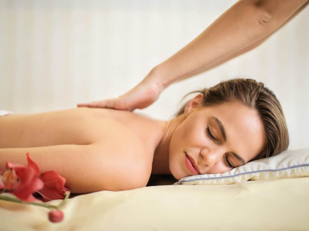 A woman enjoys a back massage with her eyes closed