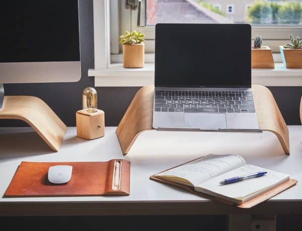 Une bureau aménagé pour le télétravail avec ordinateur, calepin et souris
