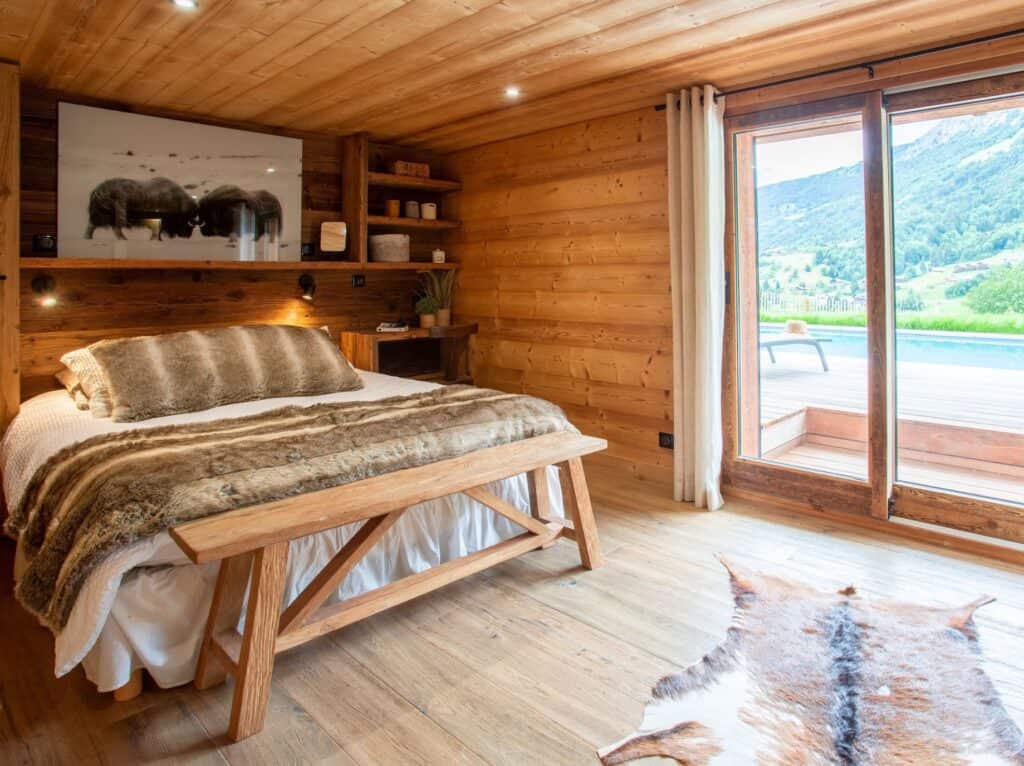 A bedroom with a double bed and doors to the terrace